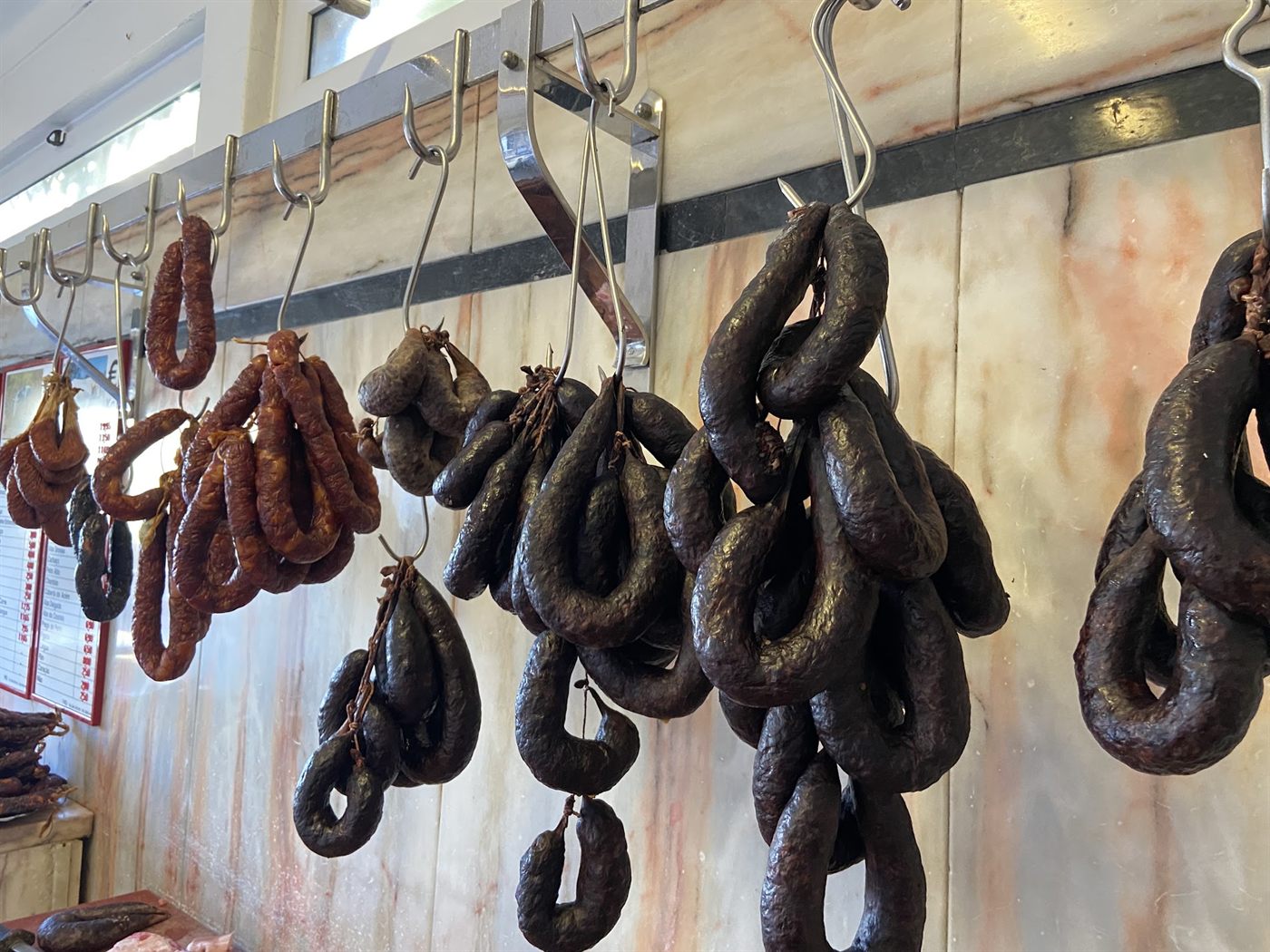 Morcelas e chouriços de fabrico próprio pendurados no talho